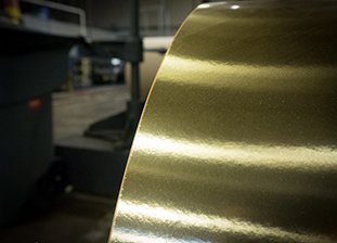 Picture of gold foil roll being produced into Sammyboard, the premium packaging board for salmon
